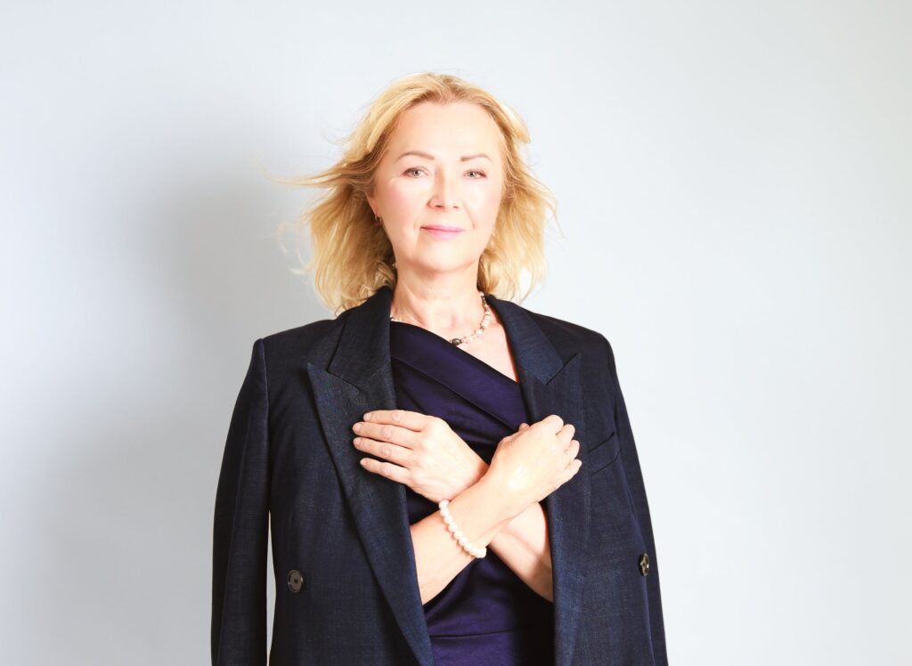 Professional business portrait of a woman in a navy blazer on a light background