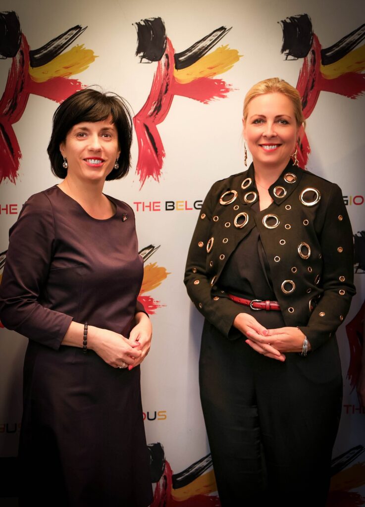 Event photography in Brussels – two women smiling in front of a colourful press wall