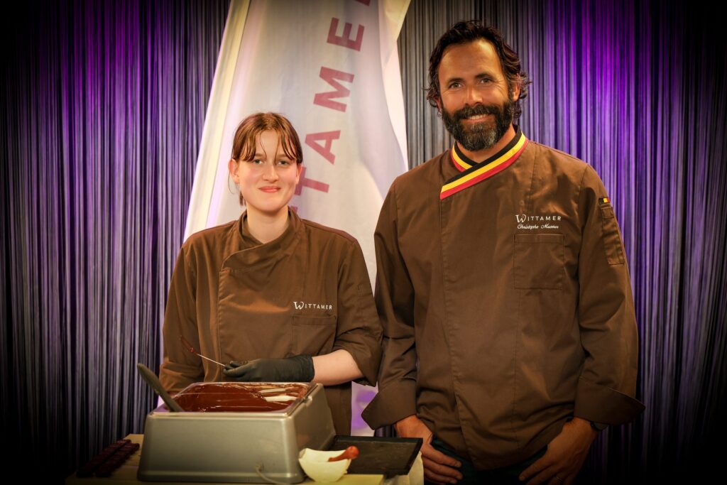 Wittamer chocolatiers at a live chocolate-making station during an event in Brussels, purple curtain backdrop